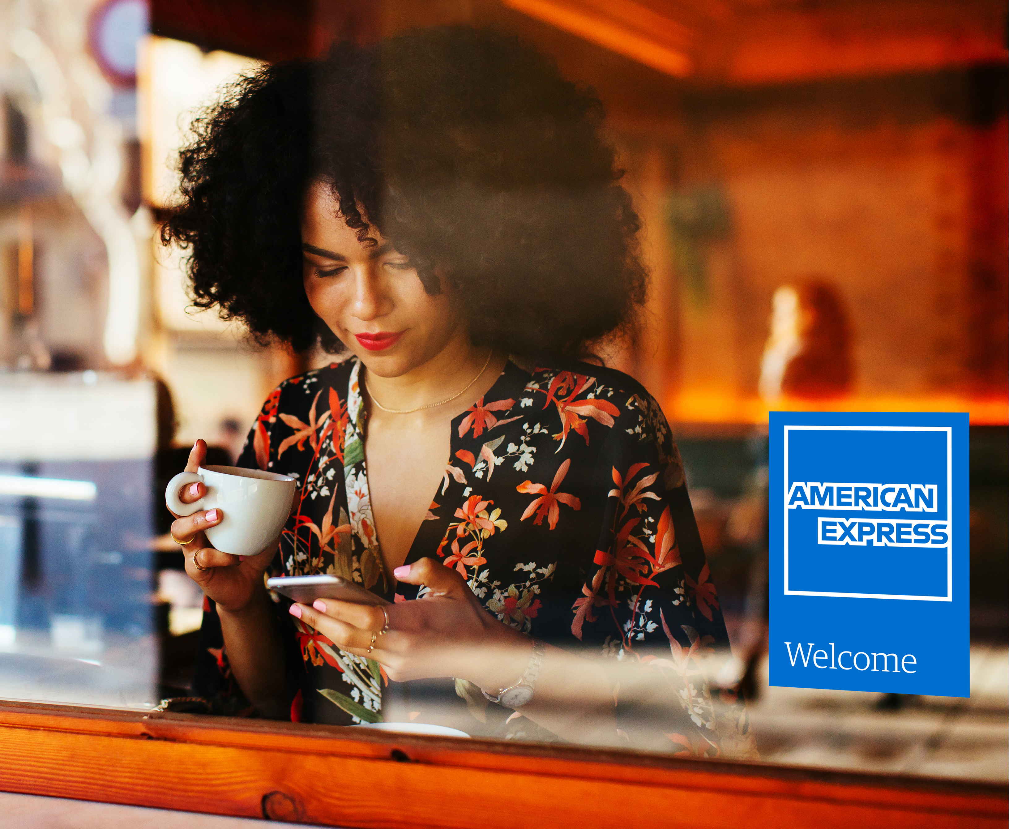 American Express welcome pack beside a customer in a café